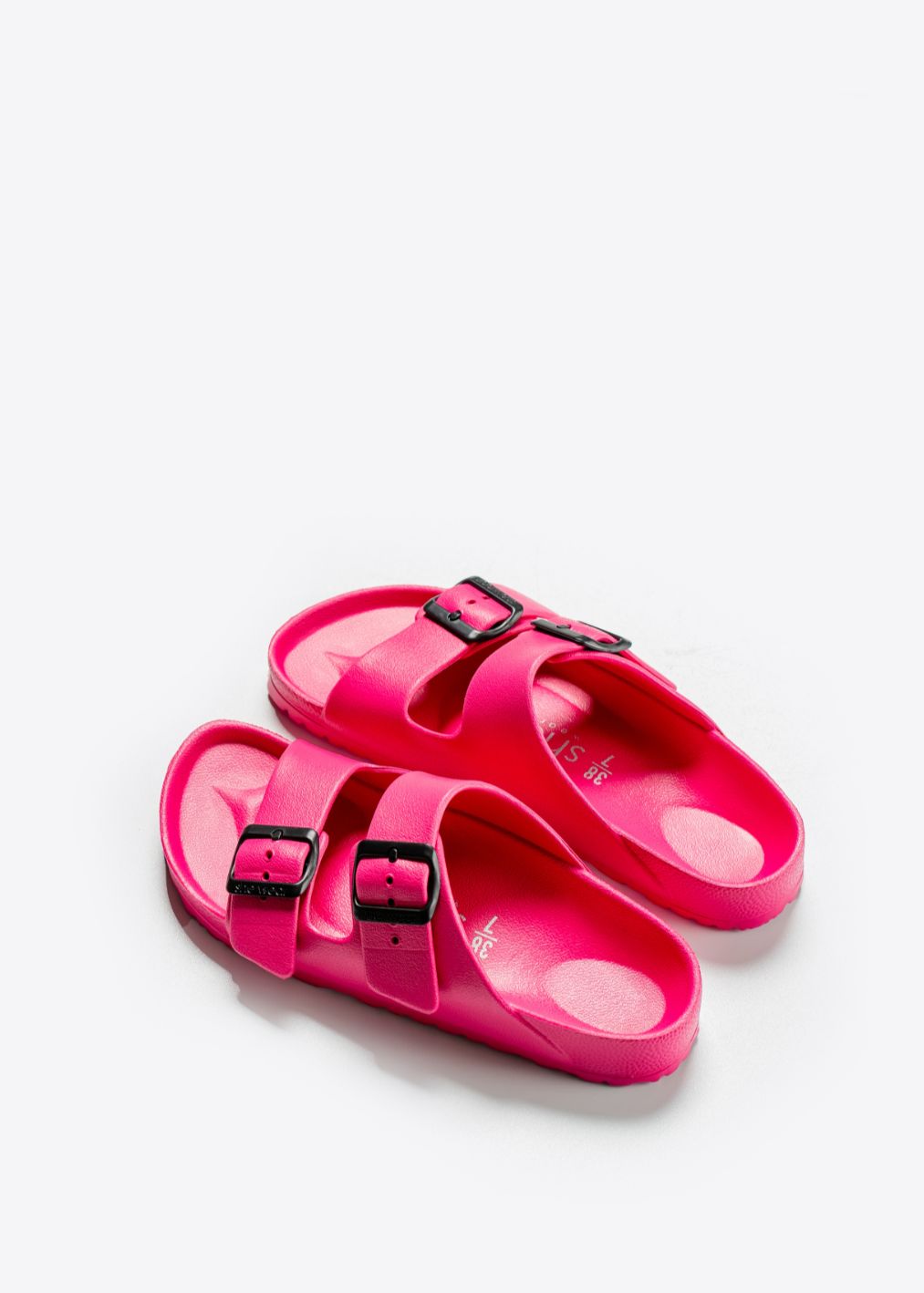 A pair of hot pink slides with a female fit contoured footbed including cradled heel