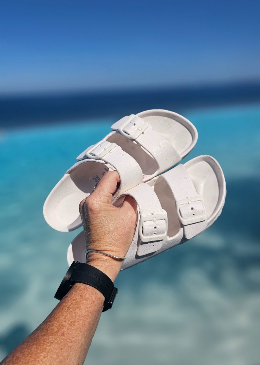 white womens slides near a blue pool